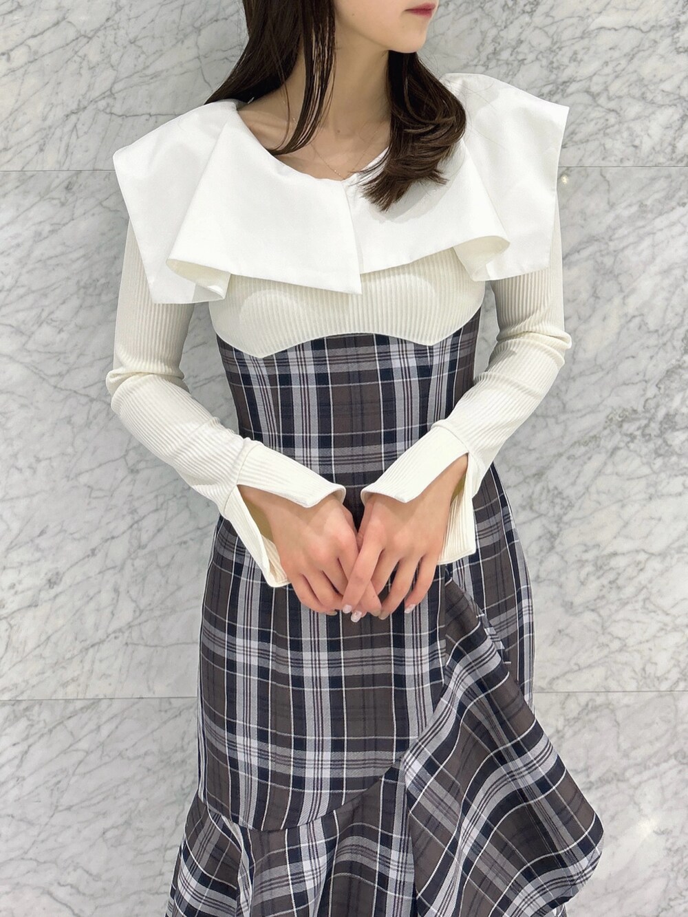 ホワイト系のワンピース、ベージュ系のブーツを着用したレディースの冬コーディネートの8枚目の写真