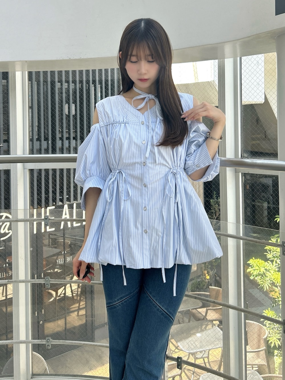 ブルー系のシャツ/ブラウス、ブルー系のデニムパンツ、ホワイト系のサンダルを着用したレディースの秋コーディネートの8枚目の写真