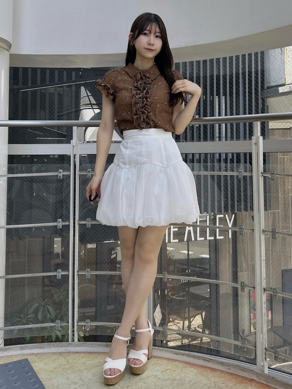 ホワイト系のサンダル、ブラウン系のシャツ/ブラウス、ホワイト系のスカートを着用したレディースの夏コーディネートの2枚目の写真