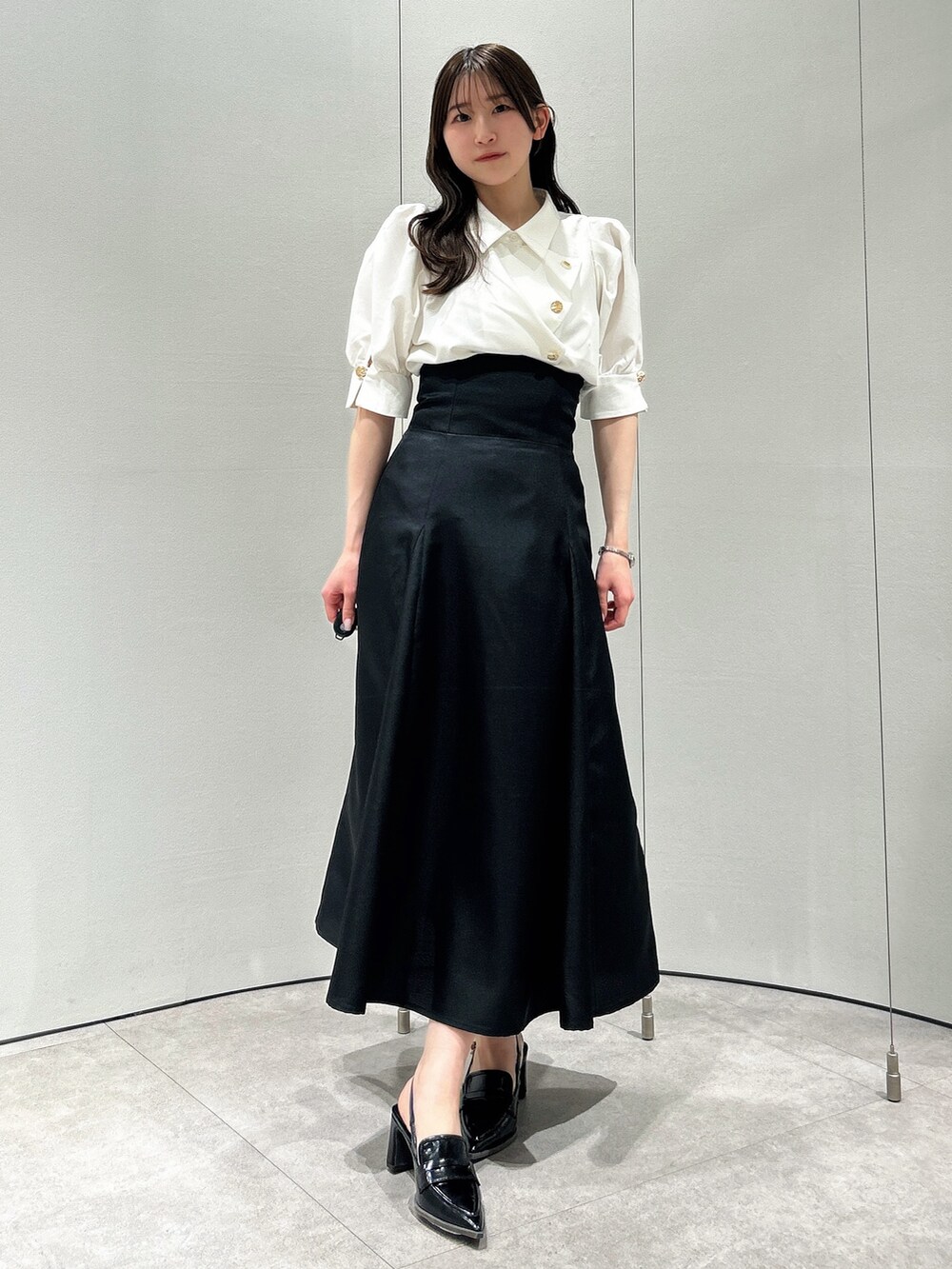 ホワイト系のシャツ/ブラウス、ブラック系のスカート、ブラック系のローファーを着用したレディースの春コーディネートの3枚目の写真