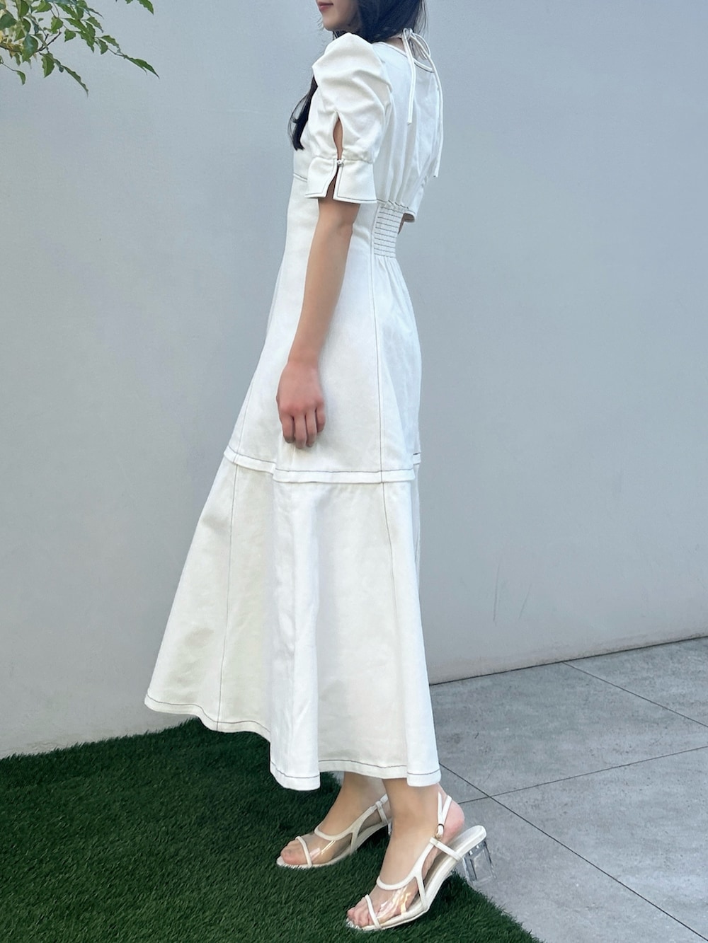 ホワイト系のワンピース、ホワイト系のサンダル、イエロー系のハンドバッグを着用したレディースの春コーディネートの3枚目の写真