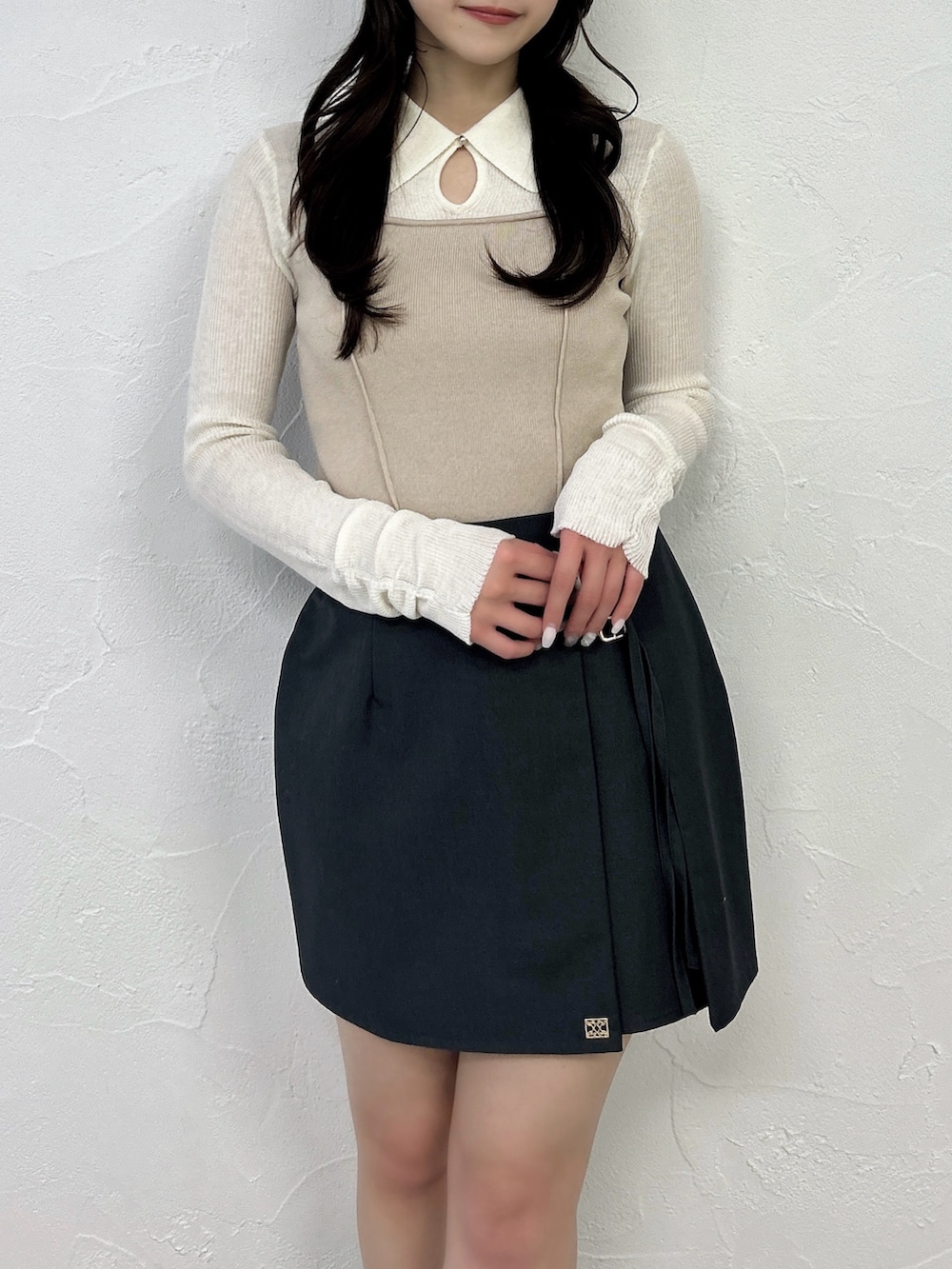 グレー系のスカート、ブラック系のブーツ、ベージュ系のニット/セーターを着用したレディースの春コーディネートの6枚目の写真