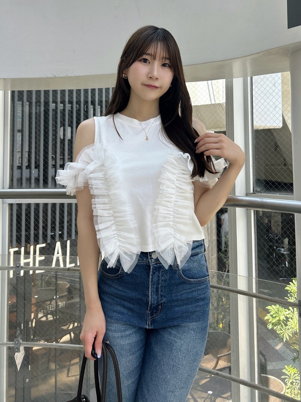 ホワイト系のTシャツ/カットソー、ブルー系のデニムパンツ、ホワイト系のサンダルを着用したレディースの夏コーディネートの7枚目の写真