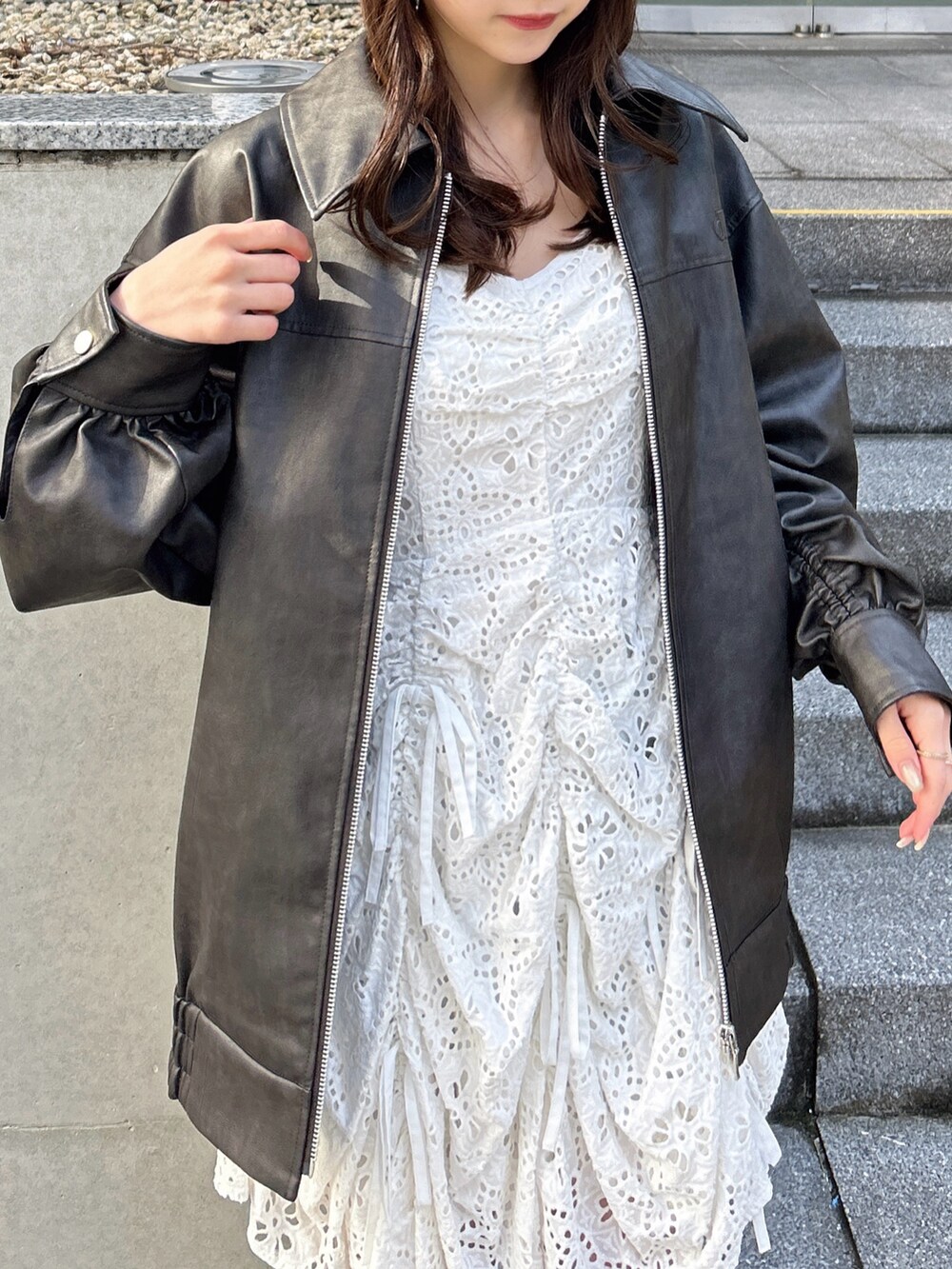 ブラック系のブルゾン、ホワイト系のワンピースを着用したレディースの冬コーディネートの6枚目の写真