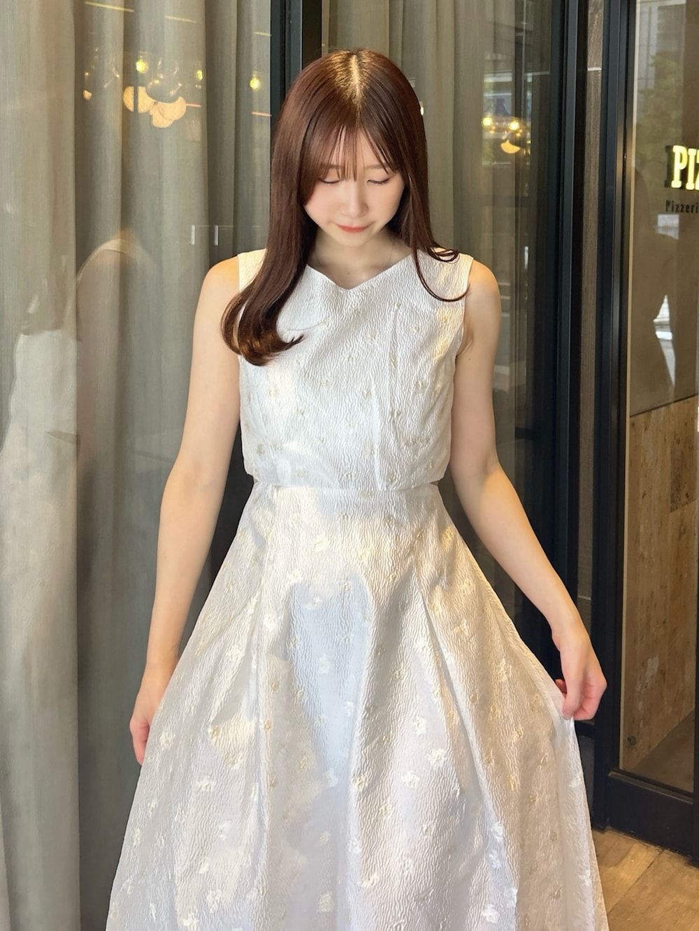 ホワイト系のワンピース、ホワイト系のサンダルを着用したレディースの秋コーディネートの9枚目の写真