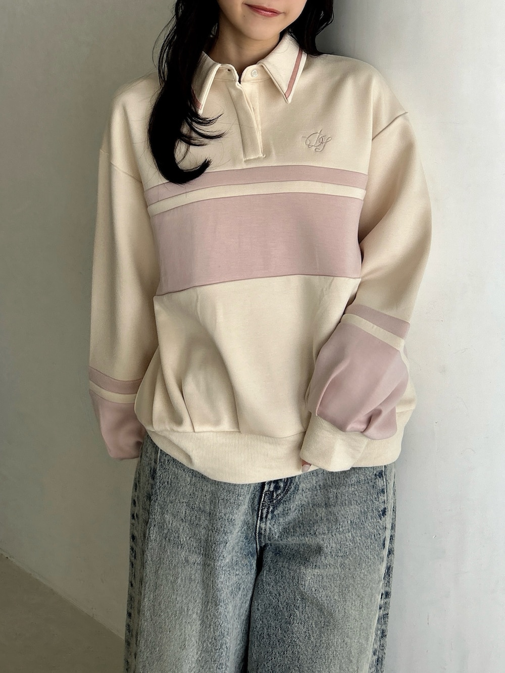 ブルー系のデニムパンツ、ホワイト系のハンドバッグ、ピンク系のスウェットを着用したレディースの冬コーディネートの8枚目の写真
