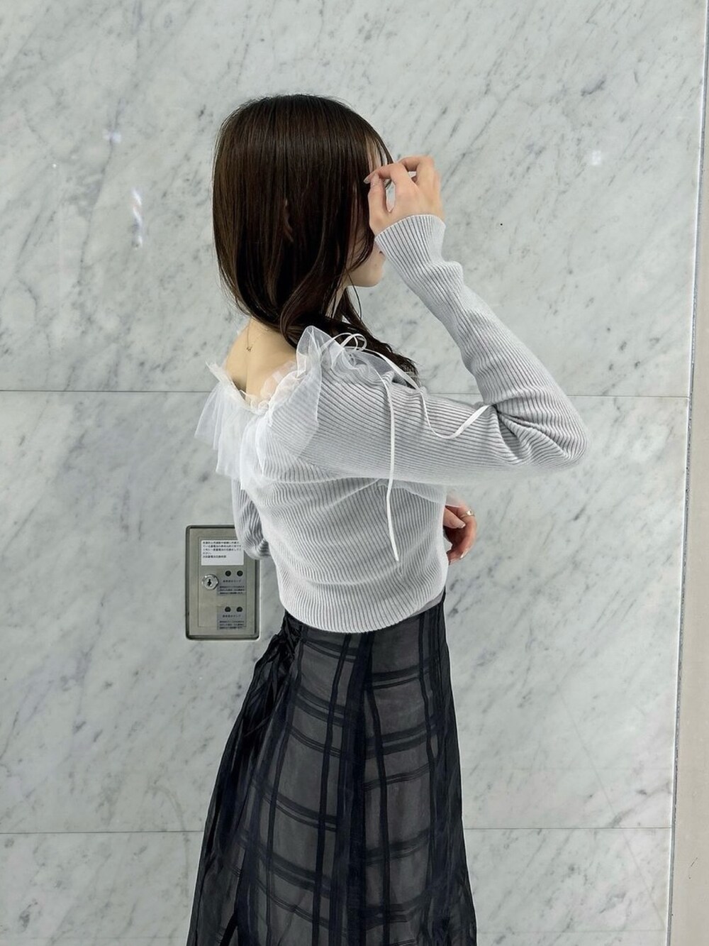 ブラック系のスカート、ブラック系のパンプス、グレー系のニット/セーターを着用したレディースの秋コーディネートの10枚目の写真