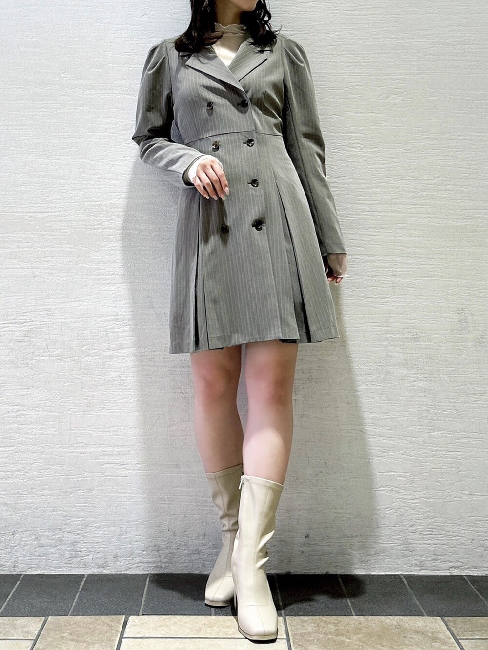 グレー系のワンピース、ホワイト系のTシャツ/カットソー、ホワイト系のブーツを着用したレディースの秋コーディネートの2枚目の写真