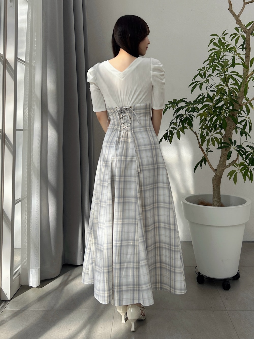 ホワイト系のワンピース、ホワイト系のパンプスを着用したレディースの冬コーディネートの5枚目の写真