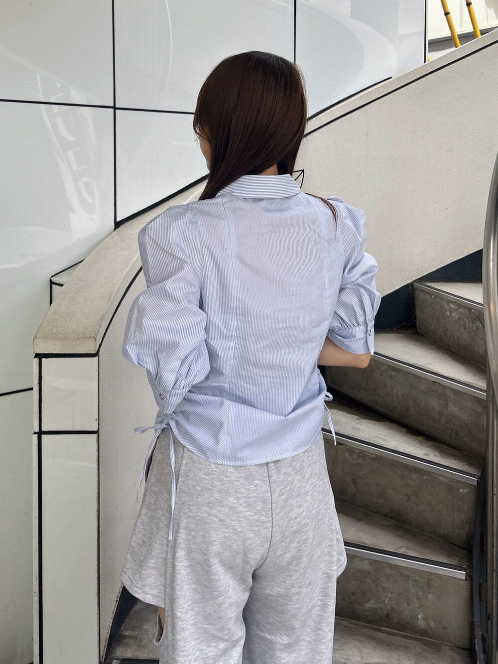 ブルー系のシャツ/ブラウス、グレー系のカーゴパンツ、ホワイト系のパンプスを着用したレディースの夏コーディネートの10枚目の写真