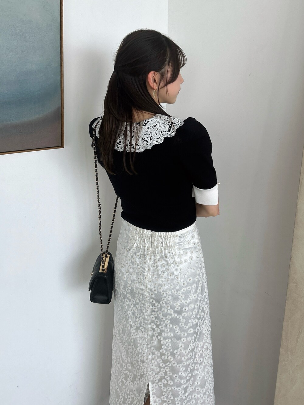 ホワイト系のスカート、ブラック系のニット/セーター、ブラック系のローファーを着用したレディースの春コーディネートの10枚目の写真