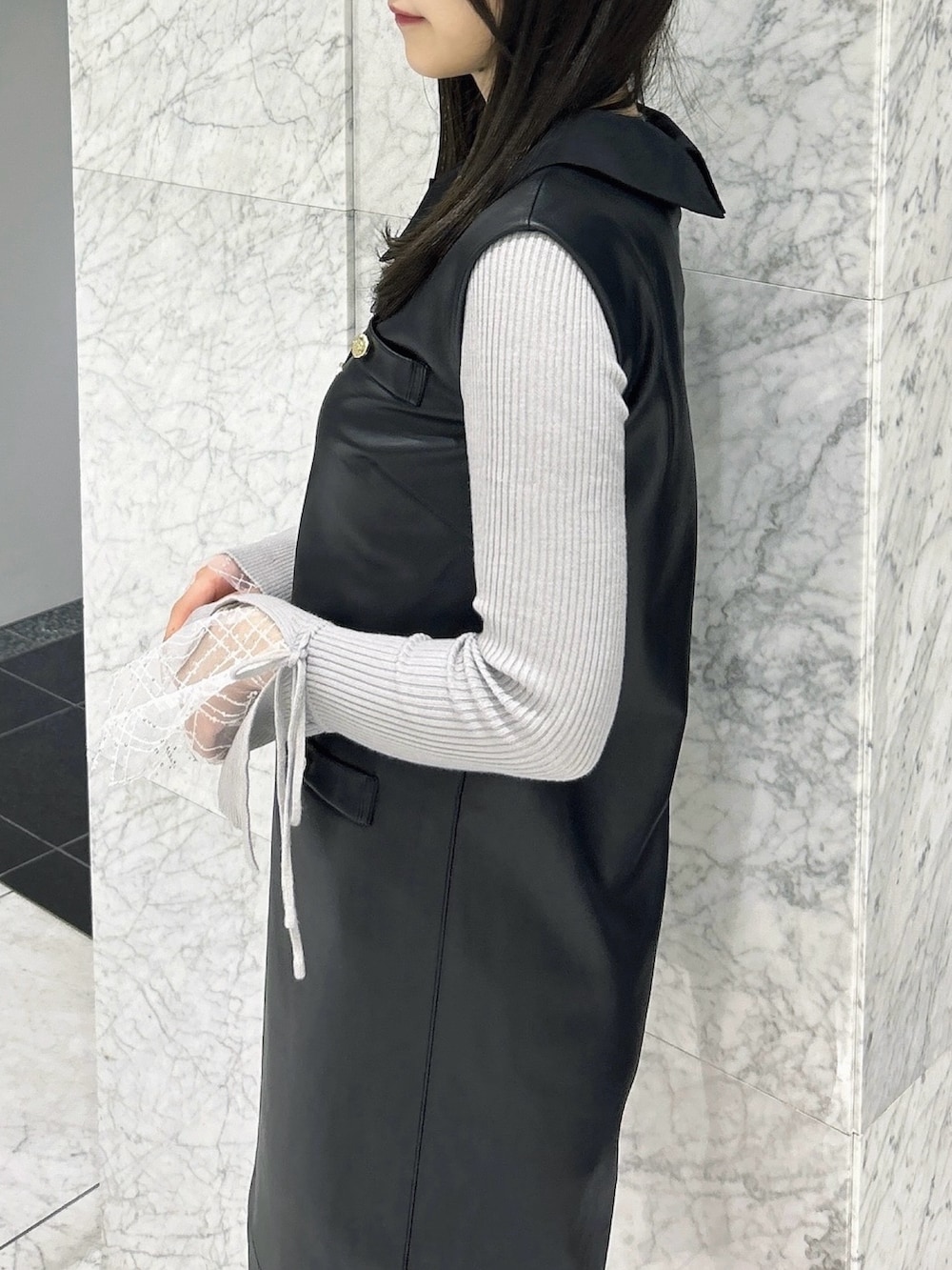 グレー系のニット/セーター、ブラック系のワンピース、ブラック系のパンプスを着用したレディースの秋コーディネートの9枚目の写真