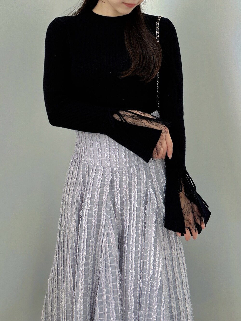 ブラック系のニット/セーター、グレー系のスカート、ブラック系のパンプスを着用したレディースの秋コーディネートの8枚目の写真