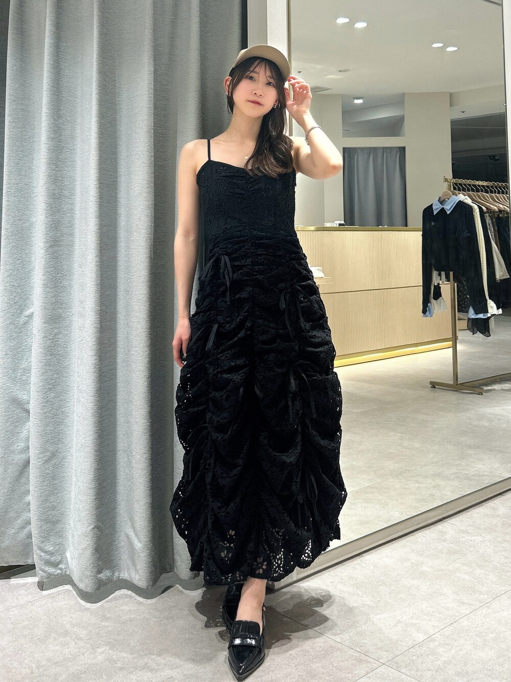 ブラック系のワンピース、ブラック系のローファー、ベージュ系のキャップを着用したレディースの春コーディネートの4枚目の写真