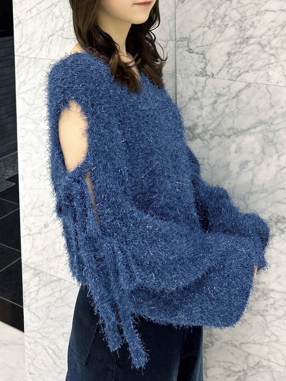 ブルー系のニット/セーター、ブルー系のデニムパンツ、ホワイト系のパンプスを着用したレディースの夏コーディネートの7枚目の写真