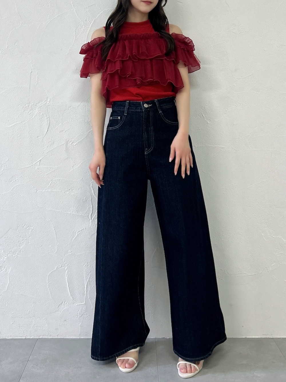 レッド系のTシャツ/カットソー、ブルー系のデニムパンツを着用したレディースの春コーディネートの2枚目の写真