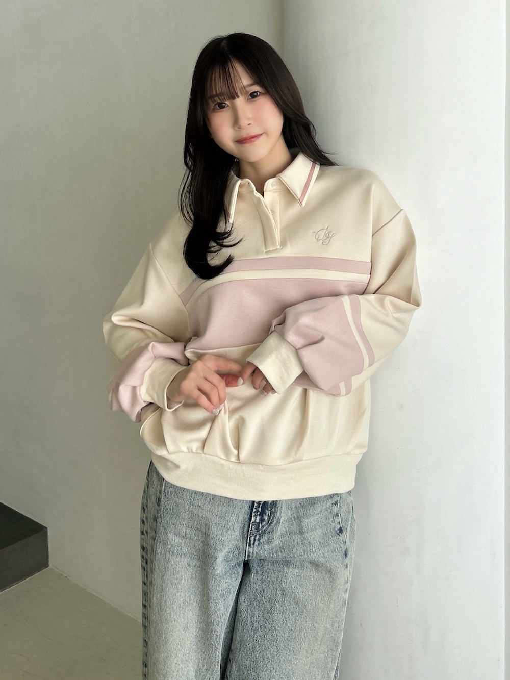 ブルー系のデニムパンツ、ホワイト系のハンドバッグ、ピンク系のスウェットを着用したレディースの冬コーディネートの7枚目の写真