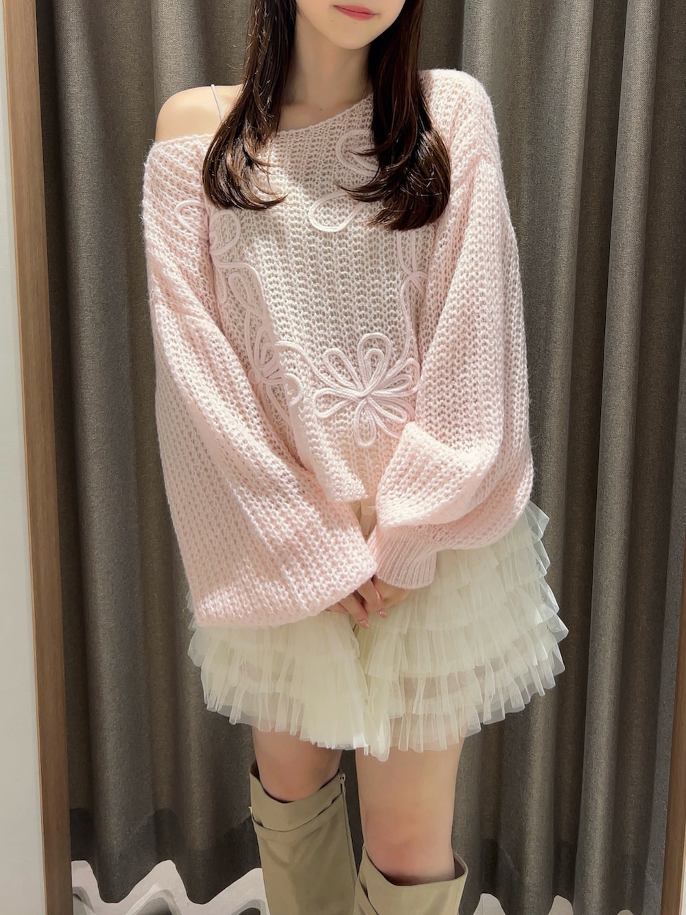 ピンク系のニット/セーター、ホワイト系のスカート、ホワイト系のブーツを着用したレディースの秋コーディネートの6枚目の写真