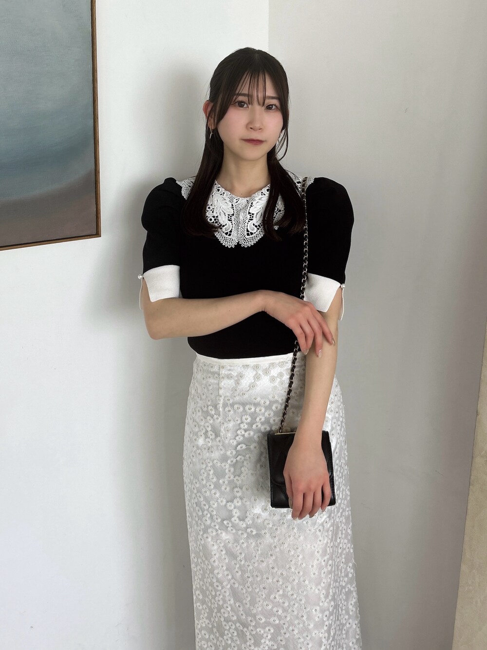 ホワイト系のスカート、ブラック系のニット/セーター、ブラック系のローファーを着用したレディースの春コーディネートの6枚目の写真