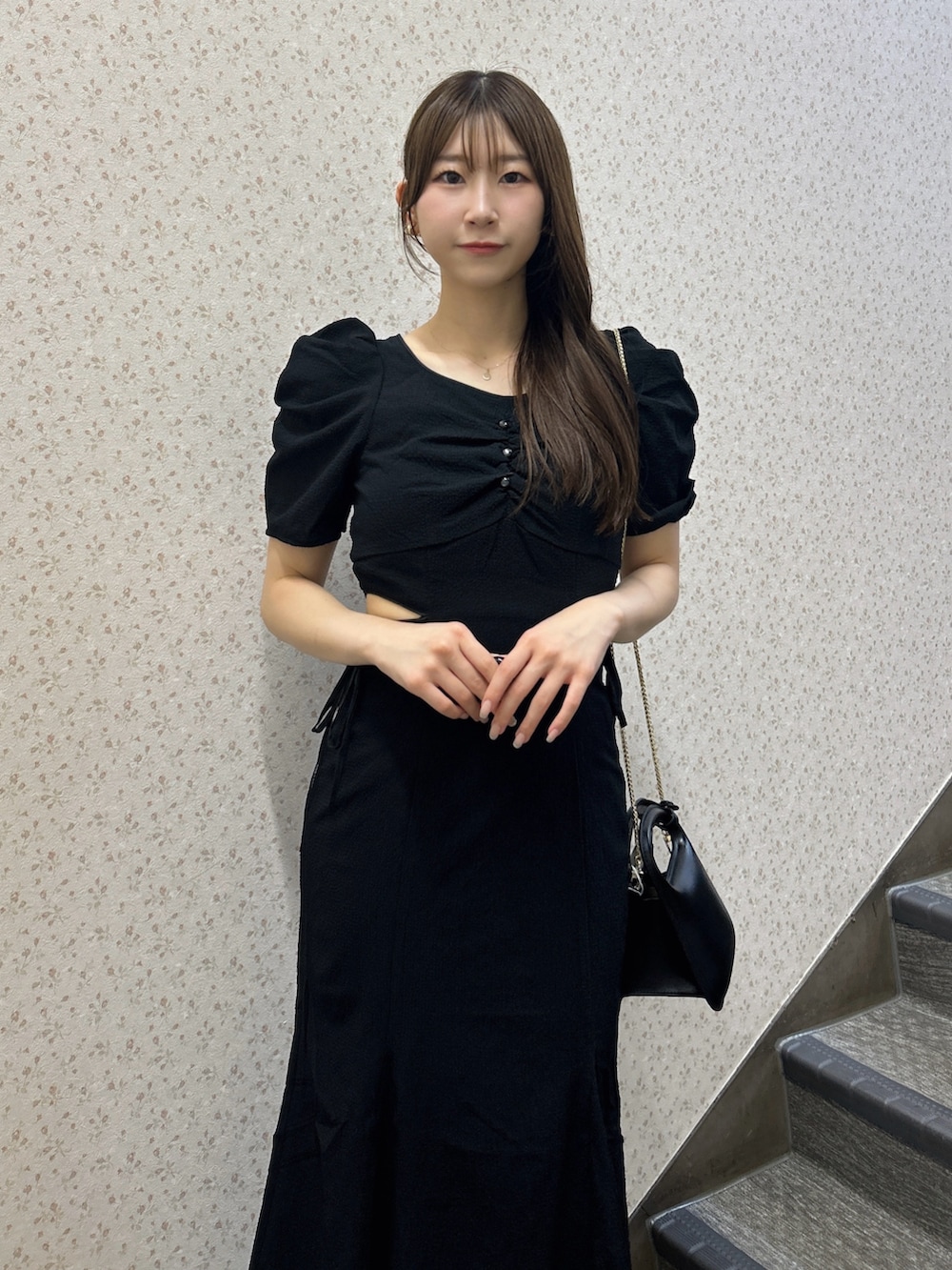 ブラック系のワンピース、ブラック系のハンドバッグ、ブラック系のサンダルを着用したレディースの夏コーディネートの6枚目の写真