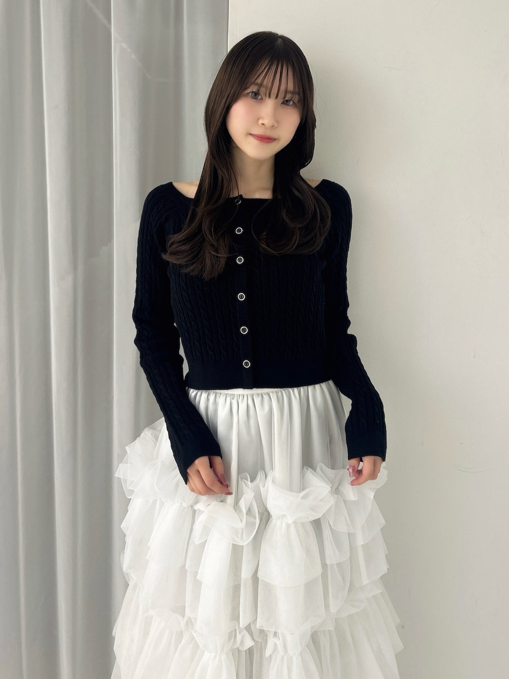 ブラック系のニット/セーター、ホワイト系のスカート、ブラック系のサンダルを着用したレディースの冬コーディネートの9枚目の写真