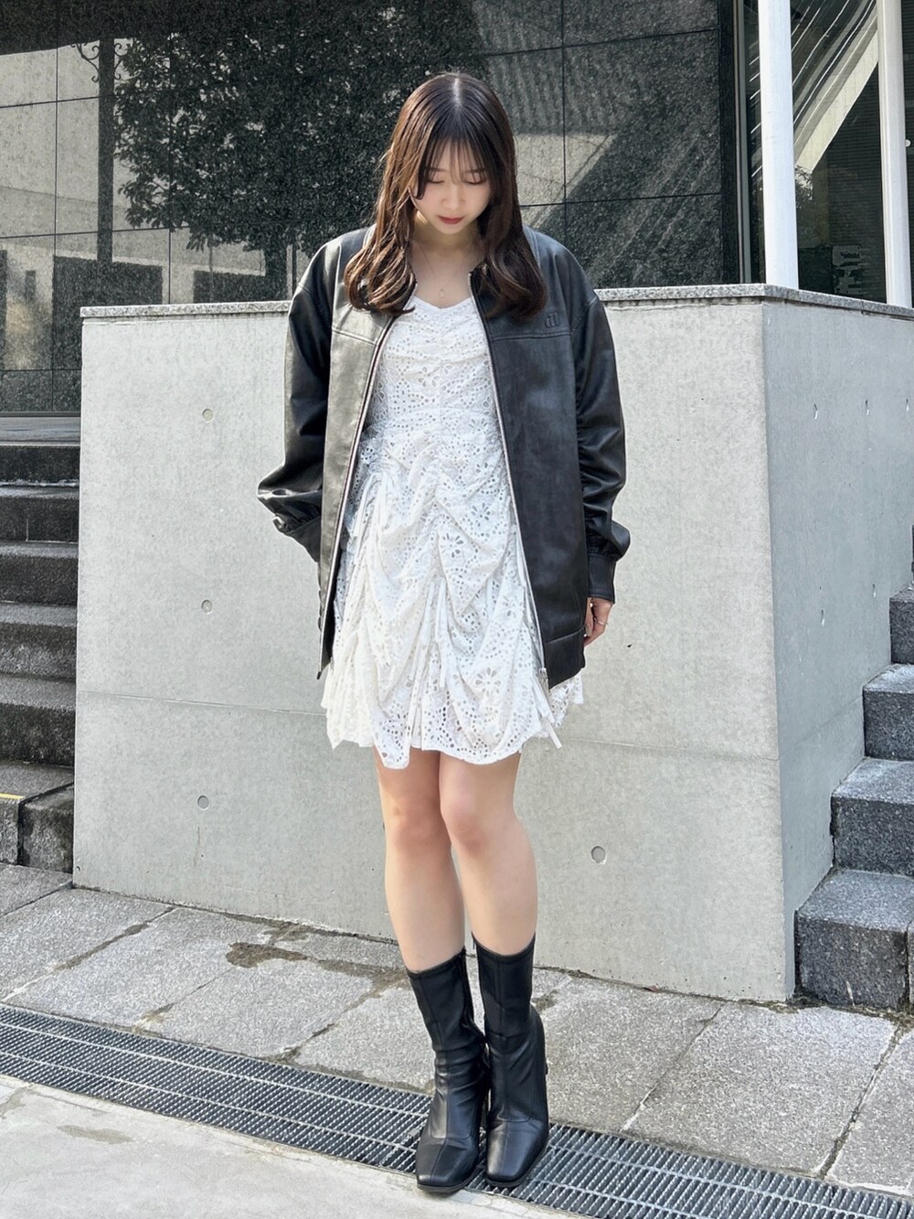 ブラック系のブルゾン、ホワイト系のワンピースを着用したレディースの冬コーディネートの4枚目の写真