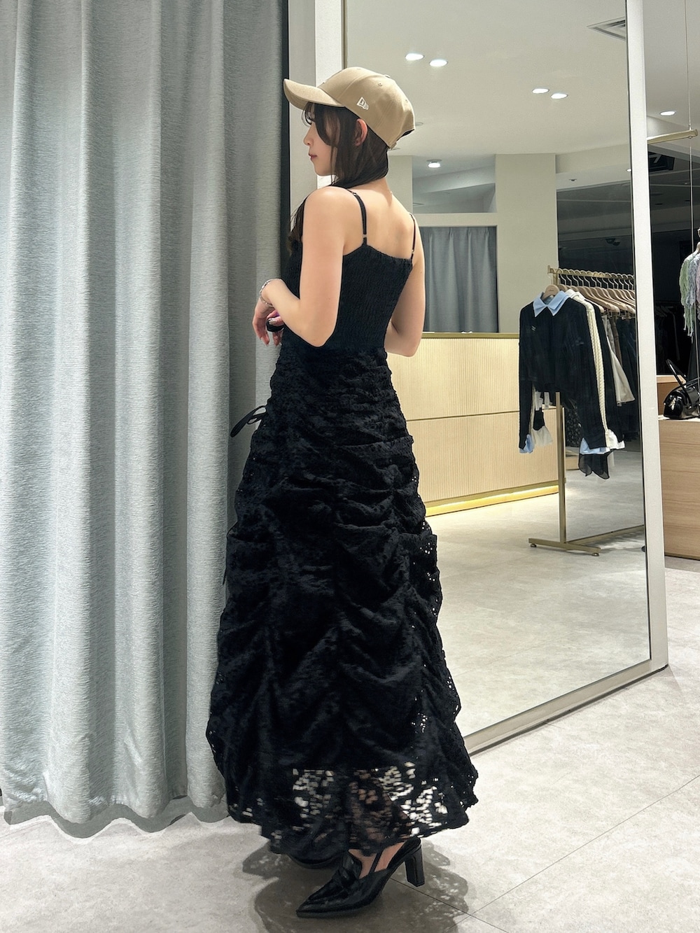 ブラック系のワンピース、ブラック系のローファー、ベージュ系のキャップを着用したレディースの春コーディネートの5枚目の写真