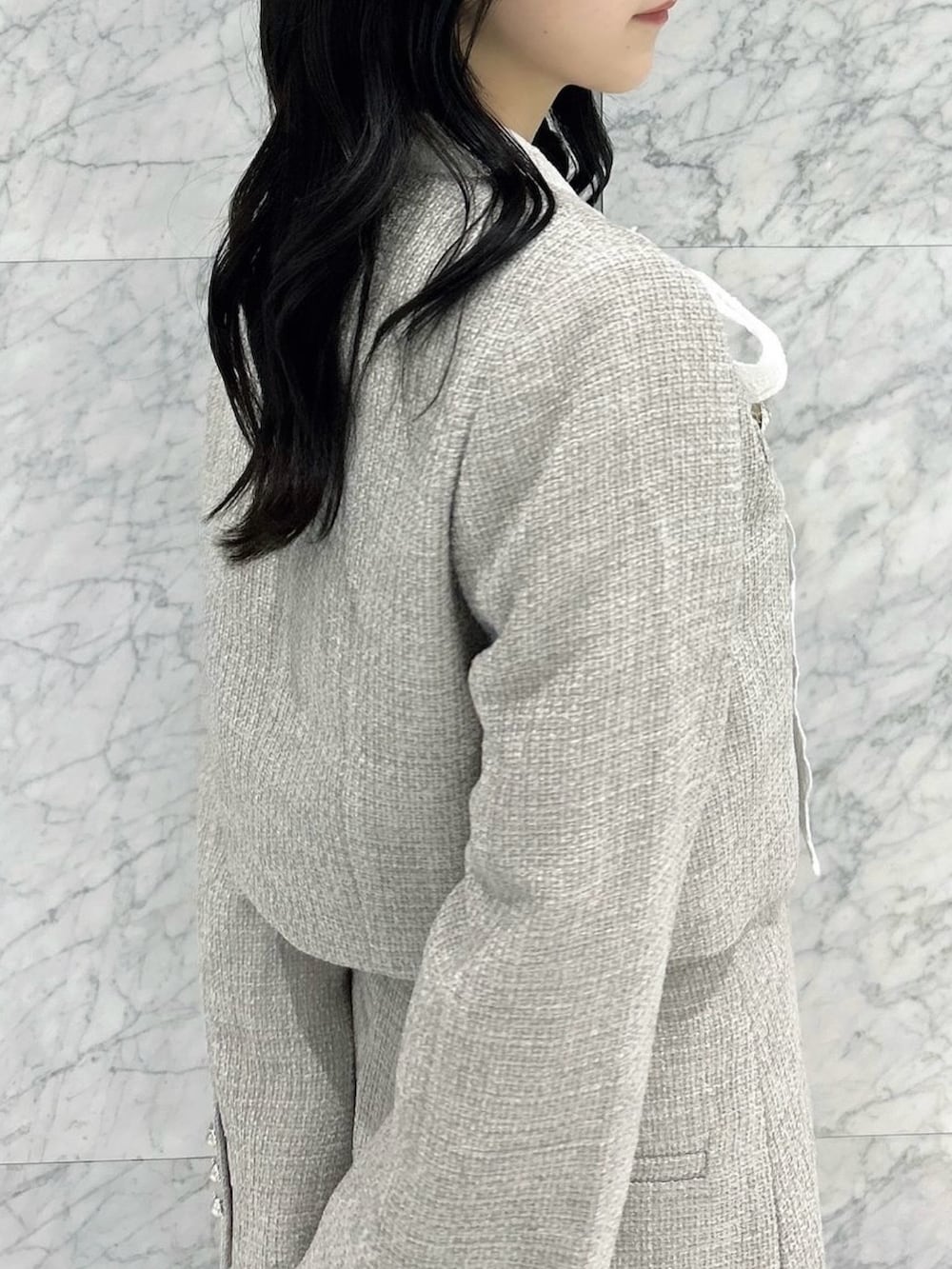 その他のブーツ、グレー系のスカート、グレー系のノーカラージャケットを着用したレディースの秋コーディネートの10枚目の写真