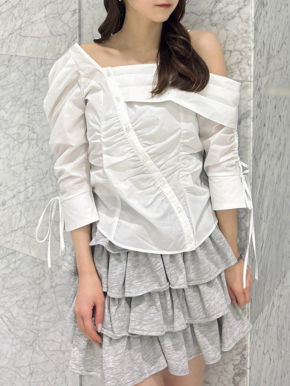 グレー系のスカート、ブルー系のハンドバッグ、ベージュ系のブーツを着用したレディースの春コーディネートの9枚目の写真