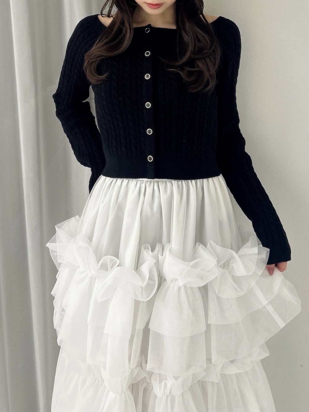 ブラック系のニット/セーター、ホワイト系のスカート、ブラック系のサンダルを着用したレディースの冬コーディネートの10枚目の写真