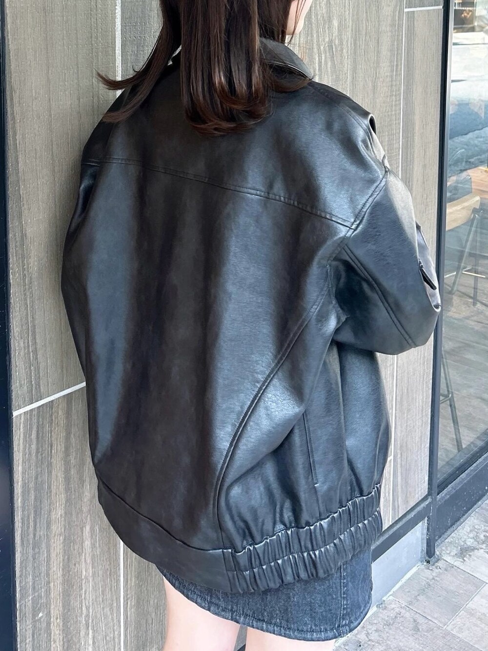 ブラック系のブルゾン、ブラック系のワンピース、ブラック系のブーツを着用したレディースの春コーディネートの9枚目の写真