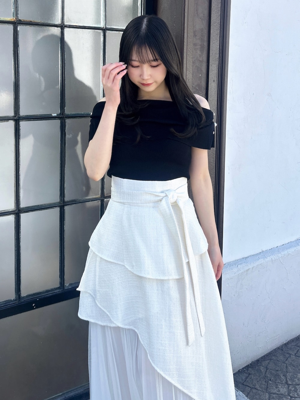 ホワイト系のスカート、ブラック系のニット/セーターを着用したレディースの冬コーディネートの9枚目の写真