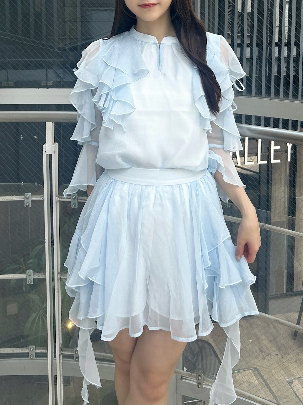 ブルー系のシャツ/ブラウス、ブルー系のスカート、ホワイト系のサンダルを着用したレディースの秋コーディネートの6枚目の写真