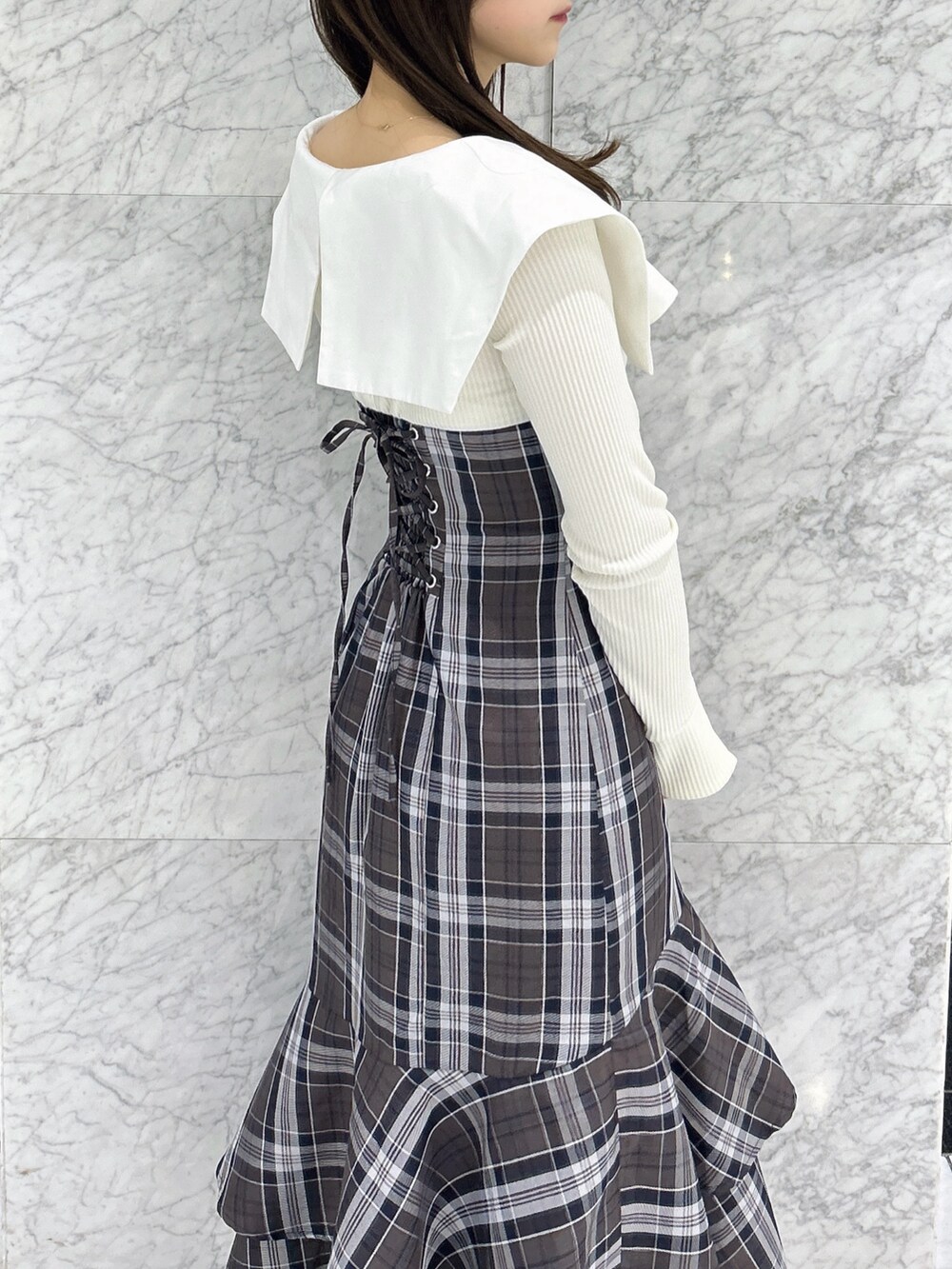 ホワイト系のワンピース、ベージュ系のブーツを着用したレディースの冬コーディネートの9枚目の写真