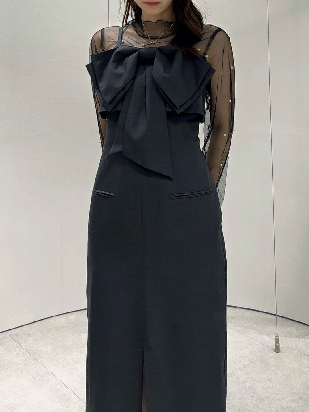 ブラック系のパンプス、ブラック系のTシャツ/カットソー、グレー系のワンピースを着用したレディースの秋コーディネートの6枚目の写真