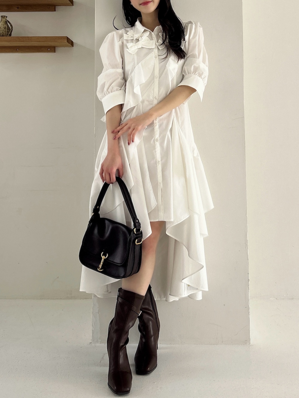 ホワイト系のワンピース、ブラウン系のブーツを着用したレディースの冬コーディネートの5枚目の写真