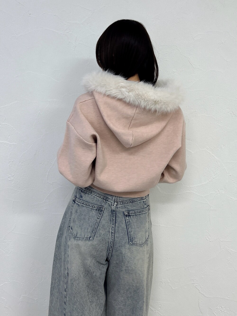 ピンク系のニット/セーター、ブルー系のデニムパンツを着用したレディースの冬コーディネートの10枚目の写真