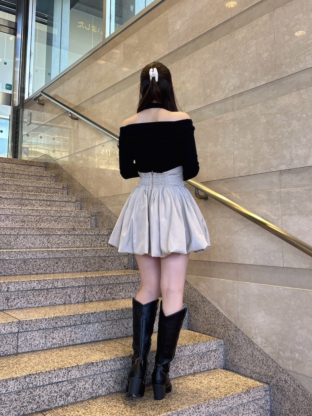 ブラック系のTシャツ/カットソー、ベージュ系のスカート、その他のブーツを着用したレディースの冬コーディネートの4枚目の写真