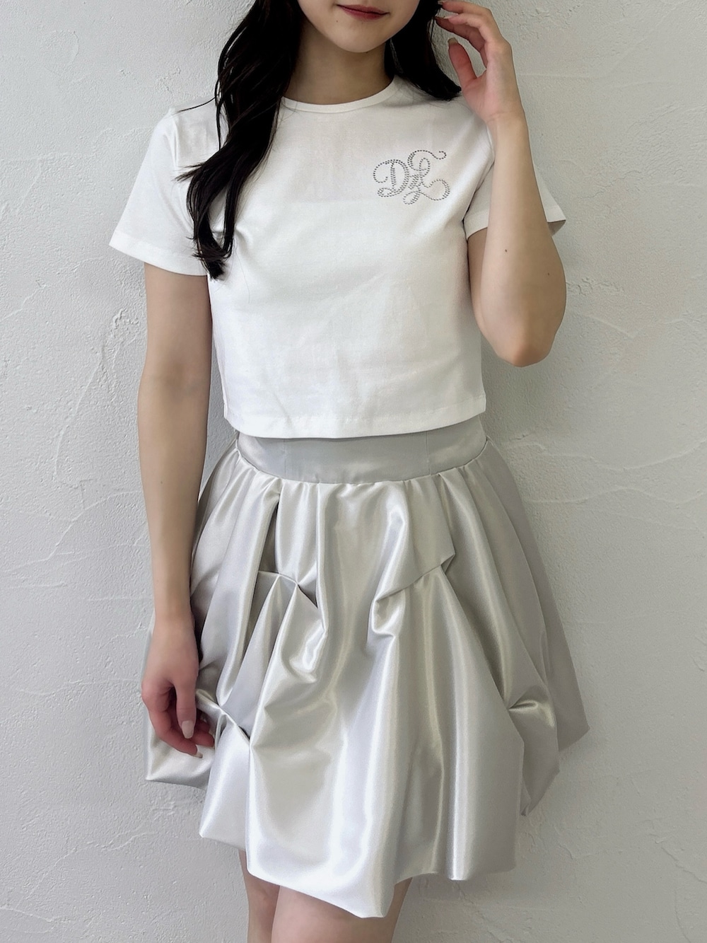 ホワイト系のTシャツ/カットソー、ホワイト系のスカート、ブラック系のサンダルを着用したレディースの春コーディネートの8枚目の写真