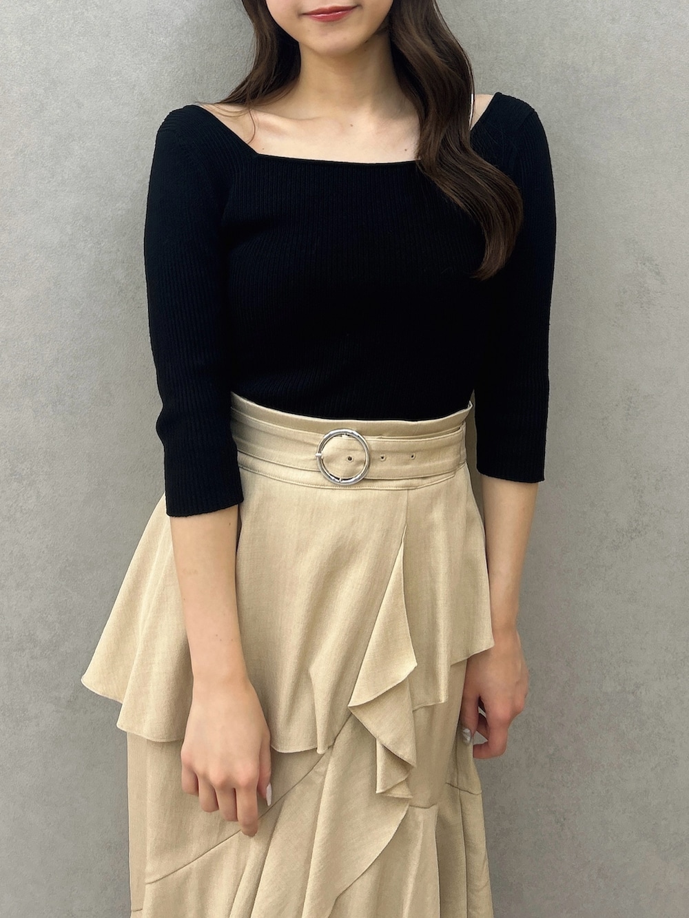 ブラック系のニット/セーター、ベージュ系のスカート、ブラック系のパンプスを着用したレディースの冬コーディネートの9枚目の写真