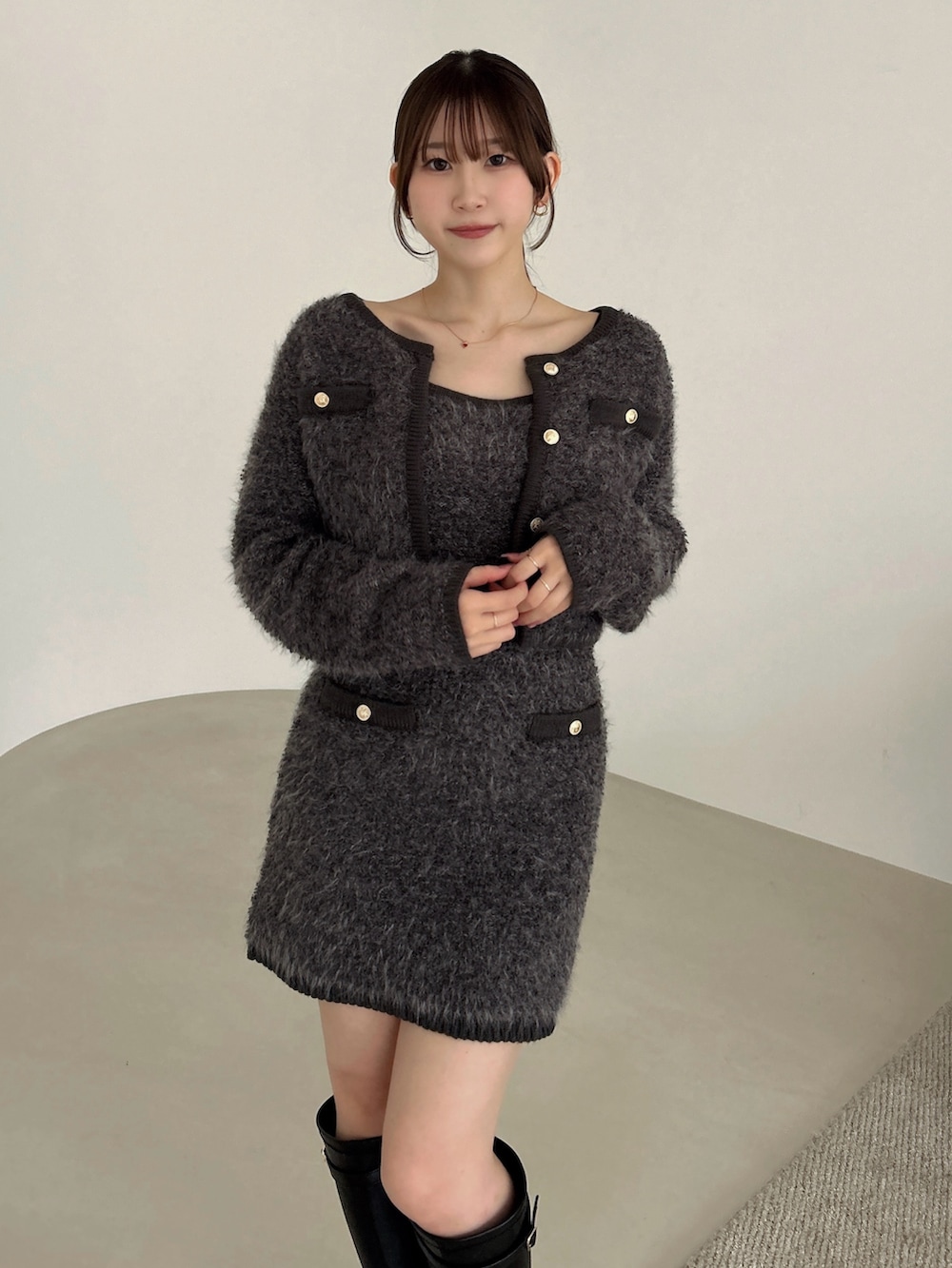 グレー系のノーカラージャケット、グレー系のワンピース、ブラック系のブーツを着用したレディースの冬コーディネートの7枚目の写真