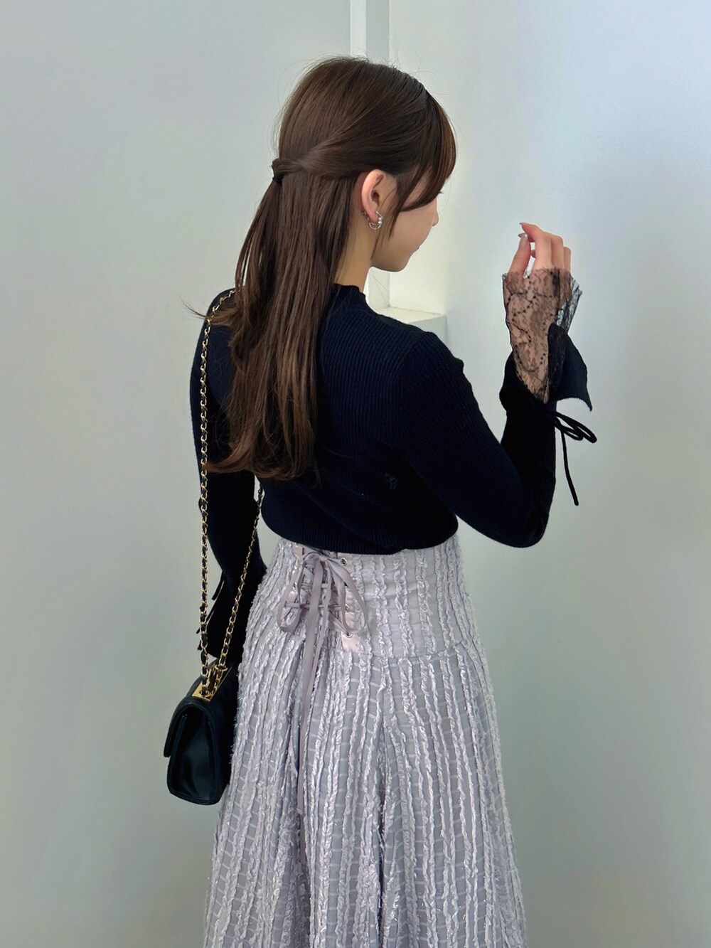 ブラック系のニット/セーター、グレー系のスカート、ブラック系のパンプスを着用したレディースの秋コーディネートの10枚目の写真