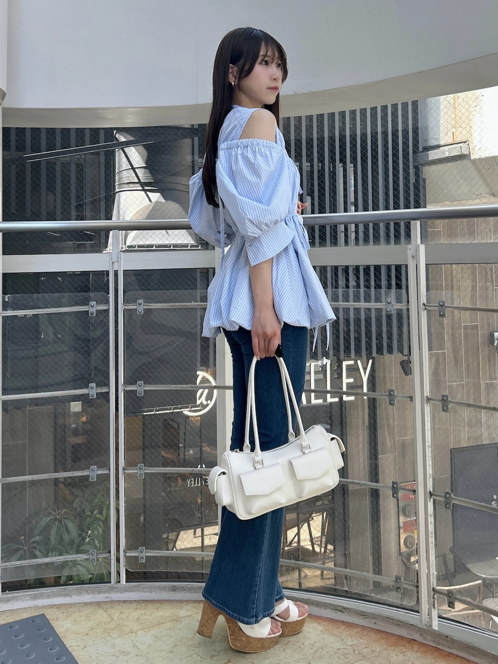 ブルー系のシャツ/ブラウス、ブルー系のデニムパンツ、ホワイト系のサンダルを着用したレディースの秋コーディネートの4枚目の写真