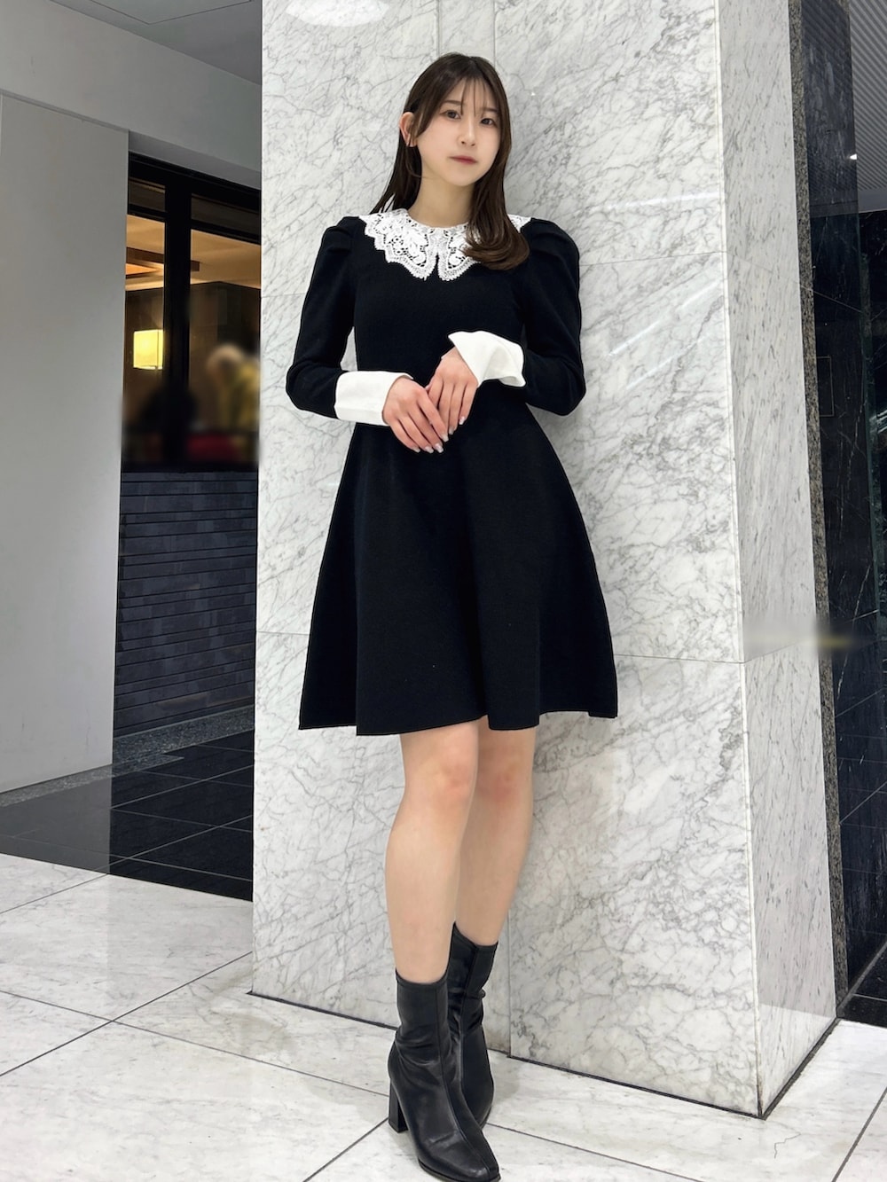 ブラック系のワンピース、ブラック系のブーツを着用したレディースの冬コーディネートの2枚目の写真