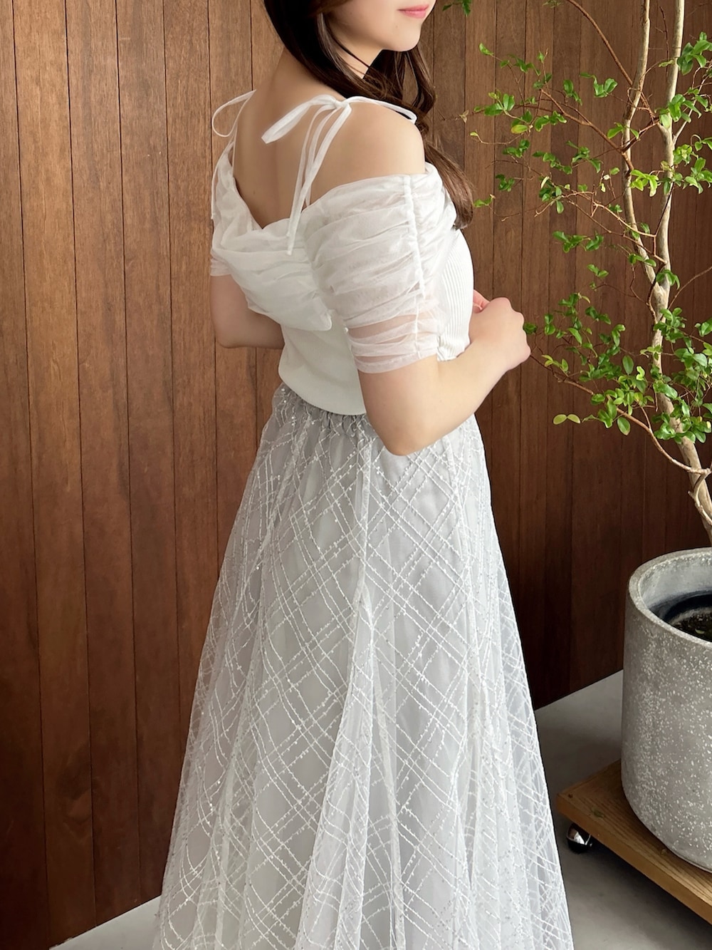 グレー系のスカート、ホワイト系のパンプス、ブラウン系のショルダーバッグを着用したレディースの夏コーディネートの9枚目の写真