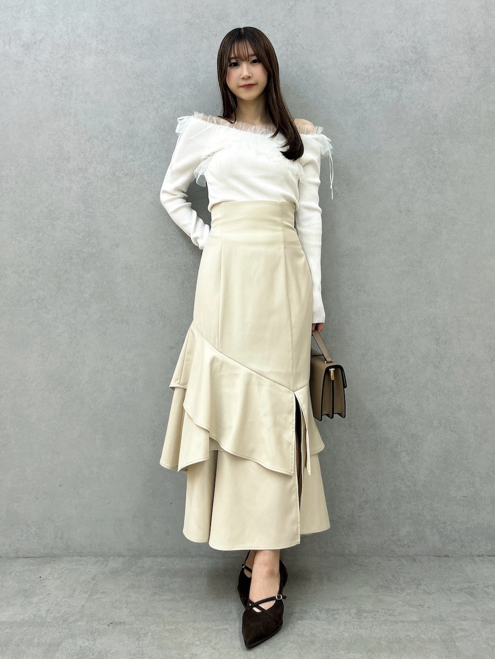 ホワイト系のニット/セーター、ホワイト系のスカート、ブラウン系のパンプスを着用したレディースの秋コーディネートの3枚目の写真