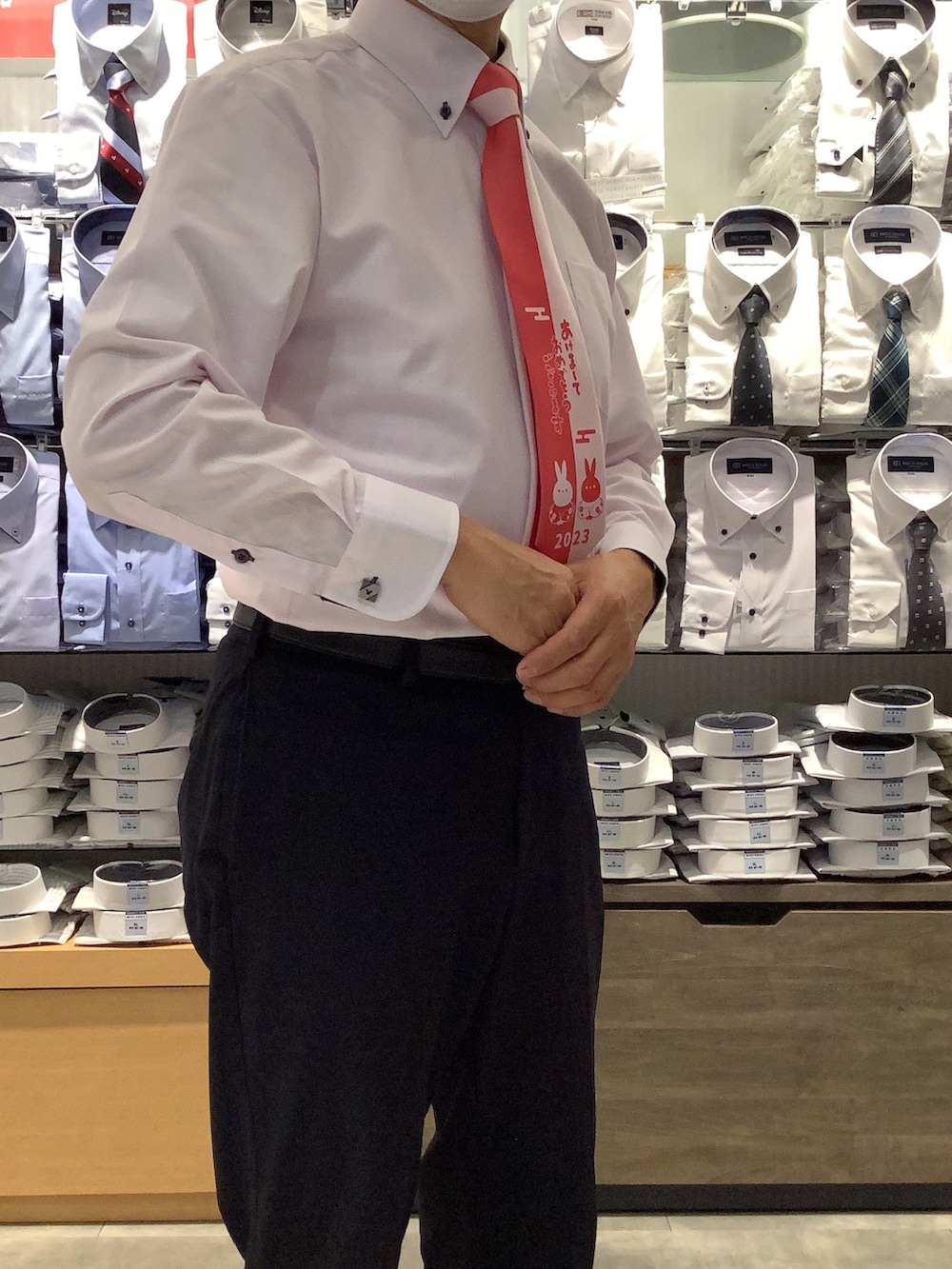 ピンク系のビジネスシャツ、シルバー系のカフリンクス、ブラック系のベルトを着用したメンズの冬コーディネートの2枚目の写真