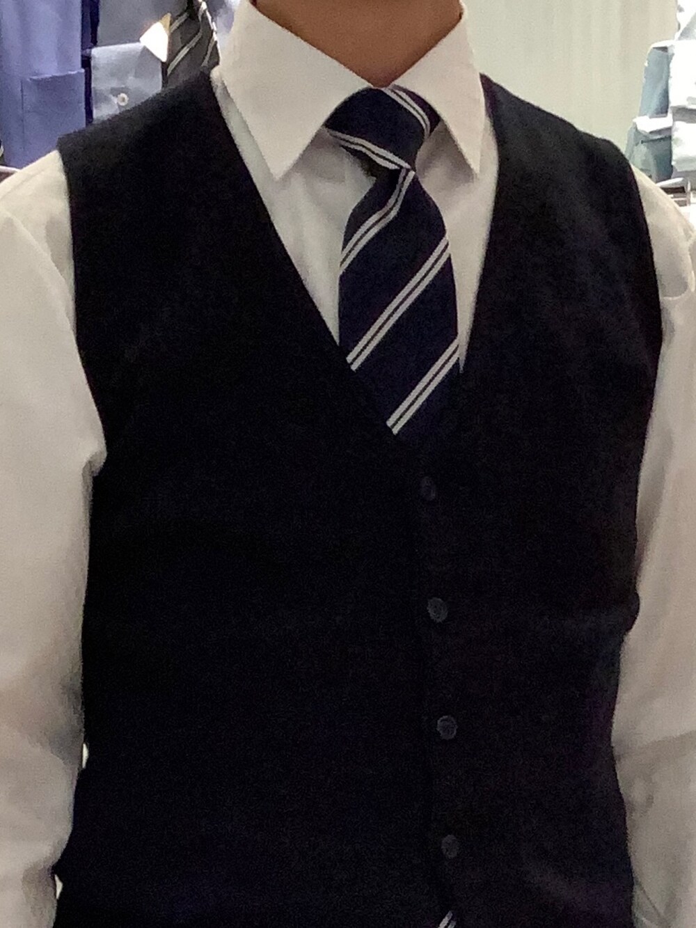 ホワイト系のビジネスシャツ、ブルー系のネクタイ、ブルー系のベストを着用したメンズの冬コーディネートの3枚目の写真