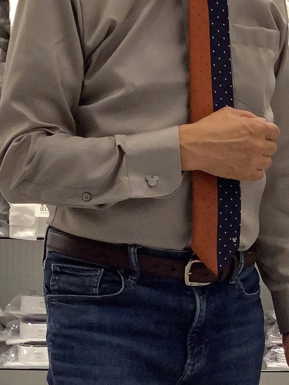 オレンジ系のネクタイ、シルバー系のカフリンクス、ベージュ系のビジネスシャツを着用したメンズの秋コーディネートの3枚目の写真