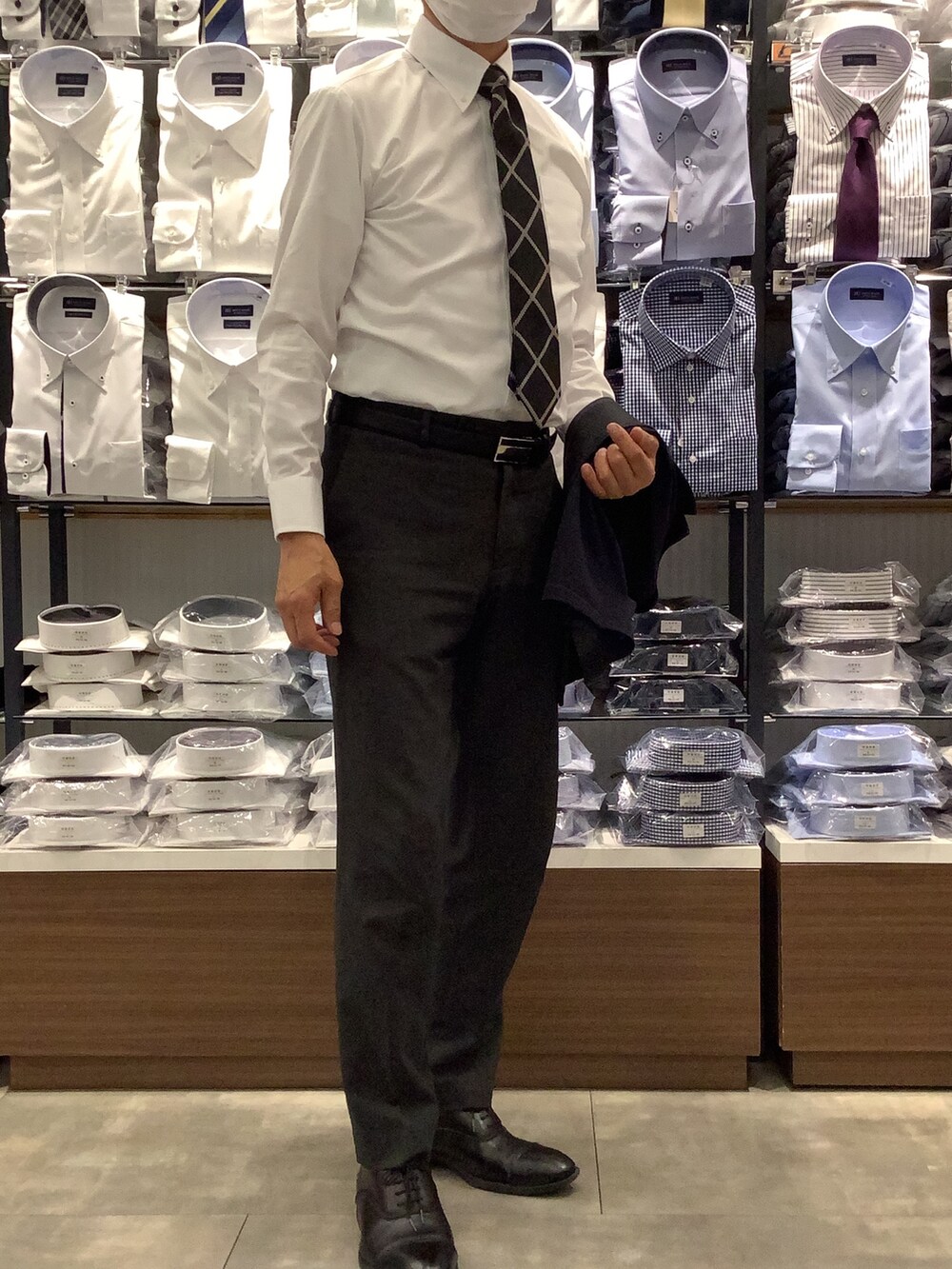 ホワイト系のビジネスシャツ、ブルー系のベストを着用したメンズの秋コーディネートの3枚目の写真